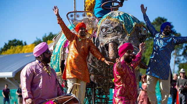 South East Asian men dancing in traditional clothing at festival
